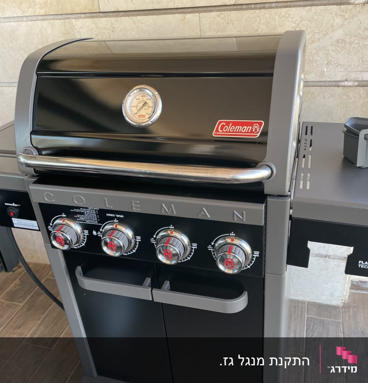 גריל גז שחור עם ארבעה כפתורים ומד חום